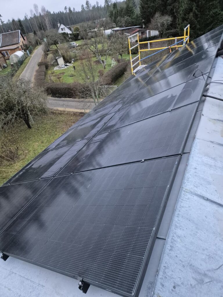 Saules paneļi uz jumta. Jauni melni saules paneļi uz metāla jumta ar kāpnēm fonā.