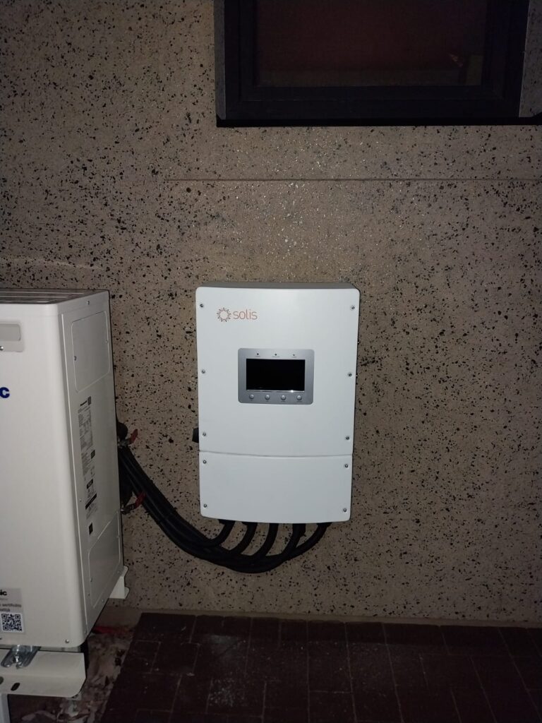 Solis invertors pie sienas blakus kondicionierim. Saules enerģijas sistēmas iekārta.